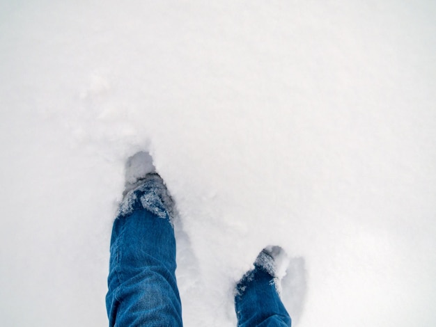 Niedriger Teil einer Person, die auf Schnee steht