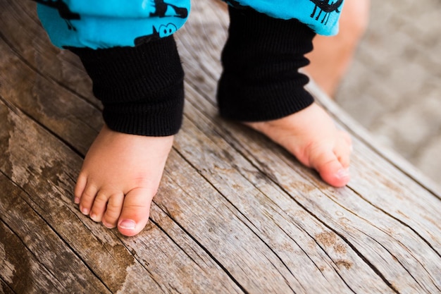 Foto niedriger teil eines jungen, der auf dem holzboden steht