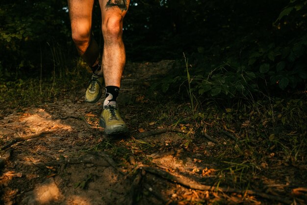 Foto niedriger teil eines mannes, der im wald rennt