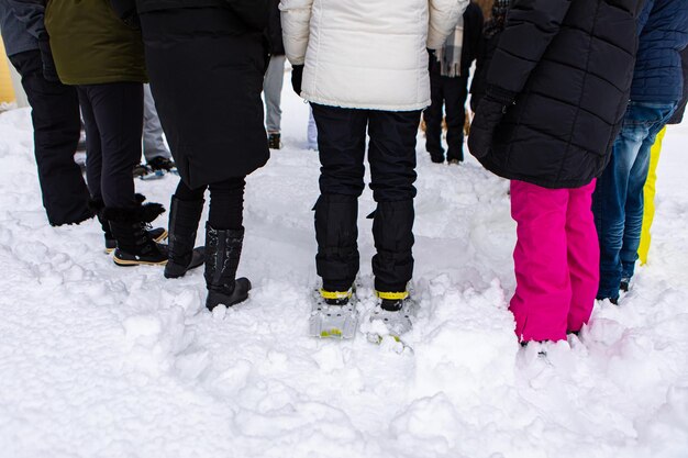Foto niedriger teil von frauen, die auf schneebedeckten menschen stehen
