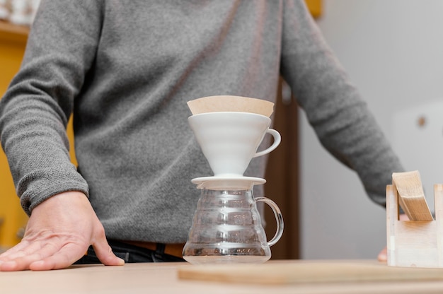 Foto niedriger winkel des männlichen barista mit kaffeefilter