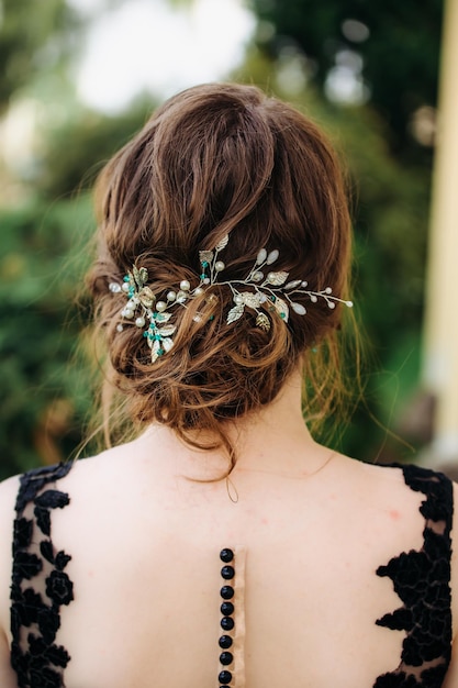 Niedriges Brötchen der Frisur der Hochzeitsfrau auf braunhaariger Rückansichtnahaufnahme