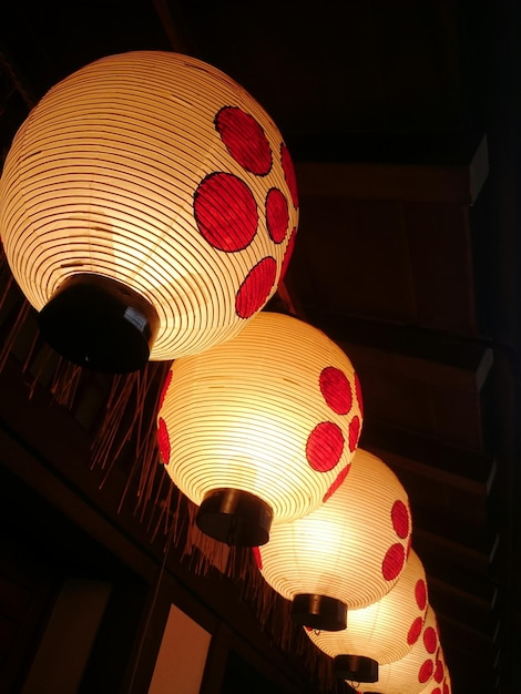 Niedrigwinkelansicht auf beleuchteten Lampen, die in einem japanischen Tempel hängen