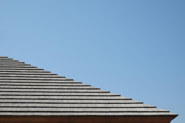 Niedrigwinkelansicht auf das Hausdach vor klarem blauen Himmel
