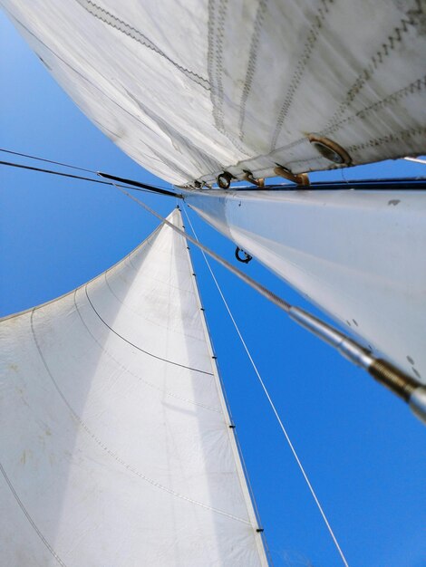 Foto niedrigwinkelansicht auf ein segelboot vor klarem blauem himmel