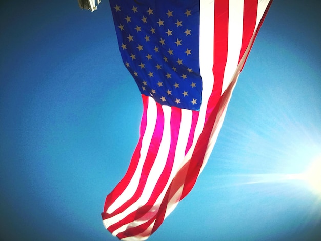 Niedrigwinkelansicht der amerikanischen Flagge, die an einem sonnigen Tag gegen den Himmel weht
