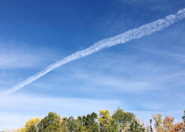 Niedrigwinkelansicht der Dampfspur gegen den blauen Himmel