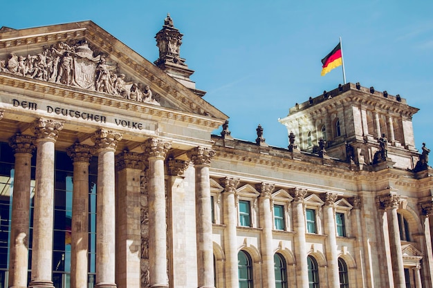 Niedrigwinkelansicht der deutschen Flagge auf dem Reichstag-Gebäude gegen einen klaren blauen Himmel