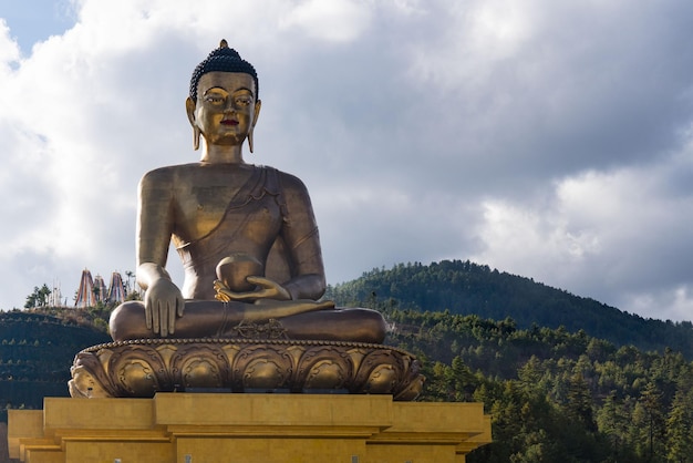 Niedrigwinkelansicht der goldenen Buddha-Statue am Baumberg gegen den bewölkten Himmel