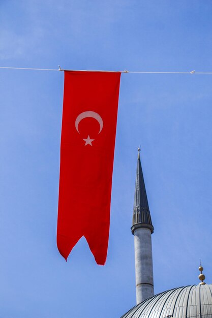 Foto niedrigwinkelansicht der roten flagge gegen den blauen himmel und das gebäude