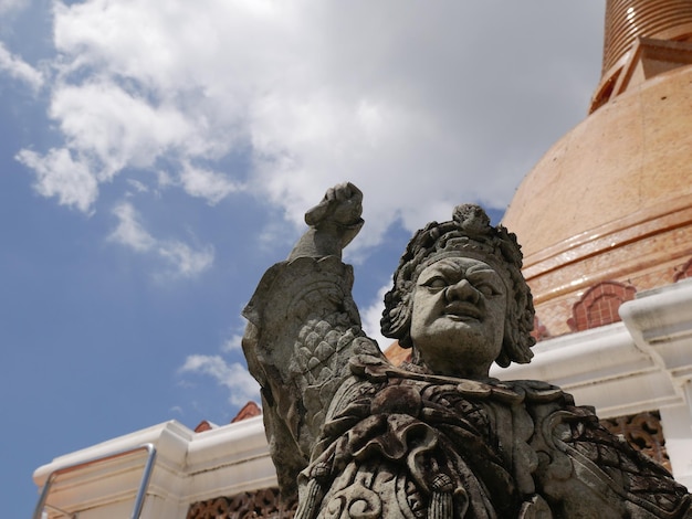 Niedrigwinkelansicht der Statue gegen das historische Gebäude gegen den Himmel