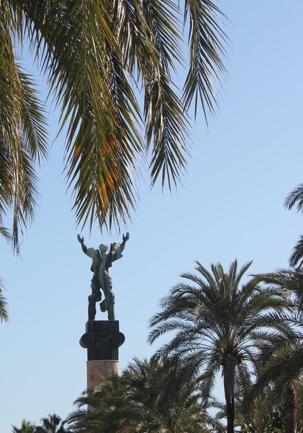 Foto niedrigwinkelansicht der statue und der palmen gegen den himmel