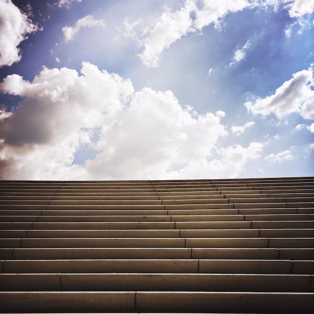 Foto niedrigwinkelansicht der treppe vor bewölktem himmel