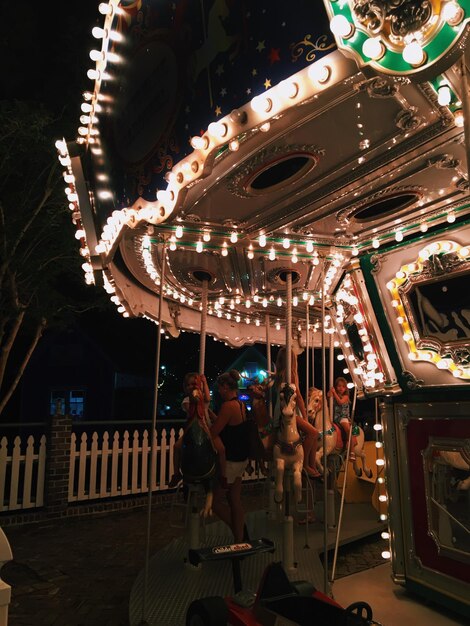 Foto niedrigwinkelansicht des beleuchteten karussells im vergnügungspark