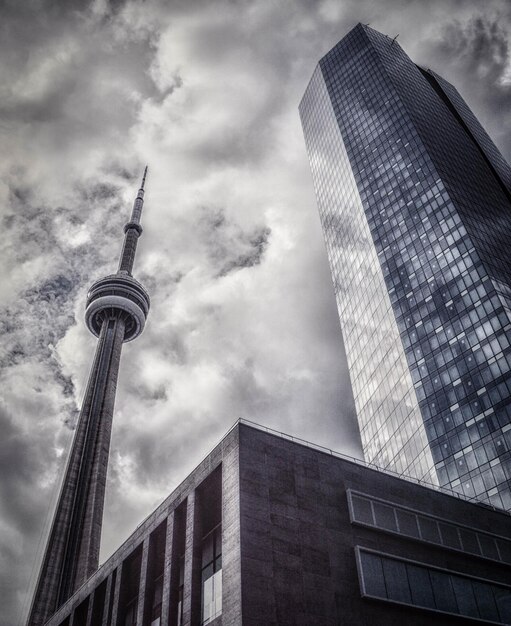 Foto niedrigwinkelansicht des cn-towers von einem wolkenkratzer gegen einen bewölkten himmel