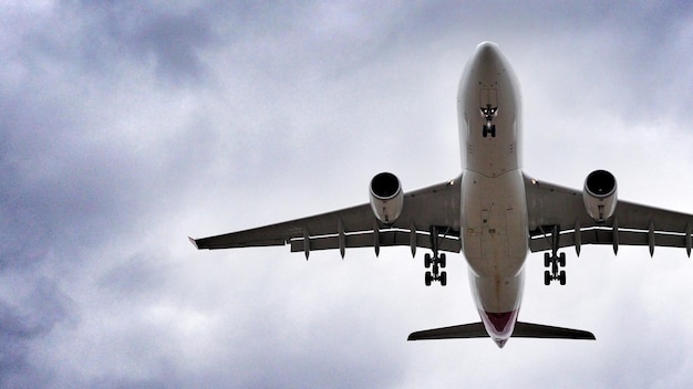 Niedrigwinkelansicht des Flugzeugs vor bewölktem Himmel
