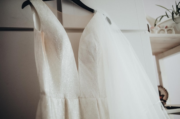 Niedrigwinkelansicht des Hochzeitskleides, das auf dem Schrank hängt