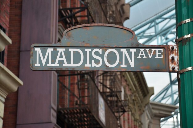 Foto niedrigwinkelansicht des madison avenue schildes gegen gebäude in der stadt