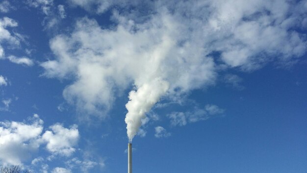 Niedrigwinkelansicht des Rauchstapels, der Umweltverschmutzung am Himmel emittiert