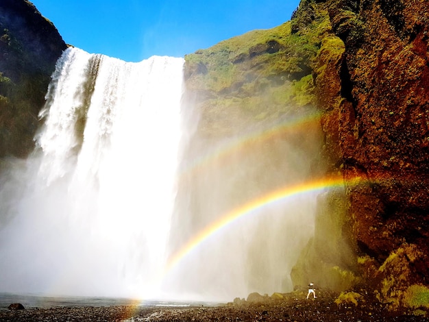 Foto niedrigwinkelansicht des regenbogens über dem wasserfall