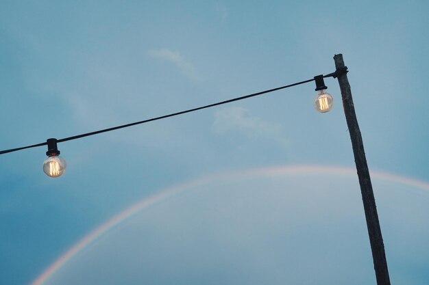 Foto niedrigwinkelansicht des regenbogens über der straßenlampe