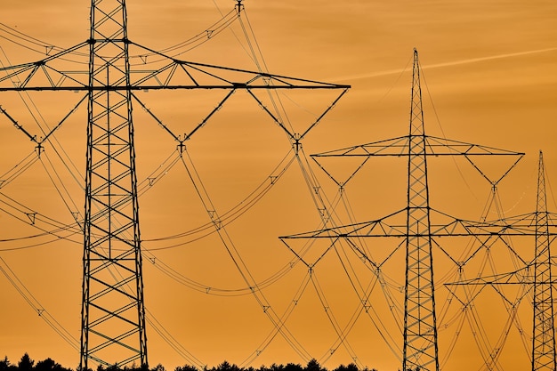 Niedrigwinkelansicht des Silhouette-Elektrizitätspylons gegen den Himmel während des Sonnenuntergangs.