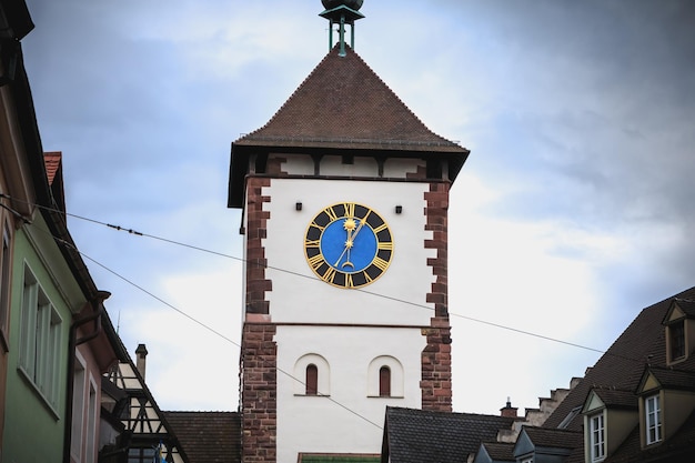 Foto niedrigwinkelansicht des uhrturms inmitten von gebäuden in der stadt gegen den himmel