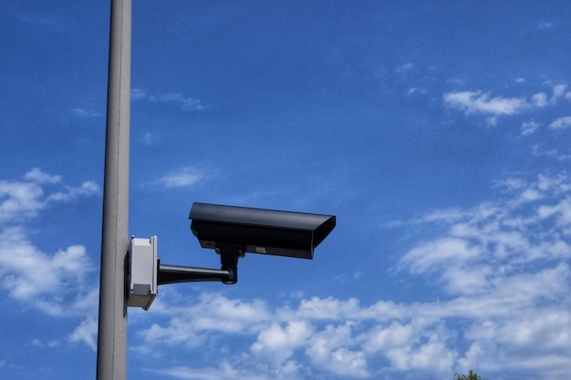 Niedrigwinkelansicht einer Überwachungskamera vor blauem Himmel