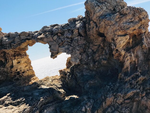 Niedrigwinkelansicht einer Felsformation im Meer vor klarem Himmel