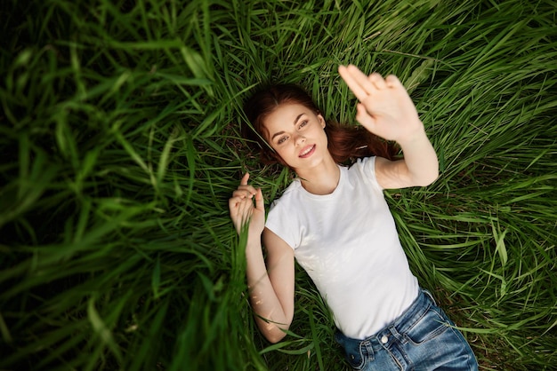 Niedrigwinkelansicht einer jungen Frau, die auf dem Gras sitzt