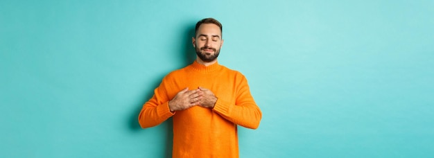 Foto niedrigwinkelansicht einer jungen frau, die ein geschenk vor blauem hintergrund hält