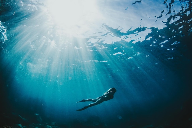 Niedrigwinkelansicht einer jungen Frau, die im Meer schwimmt