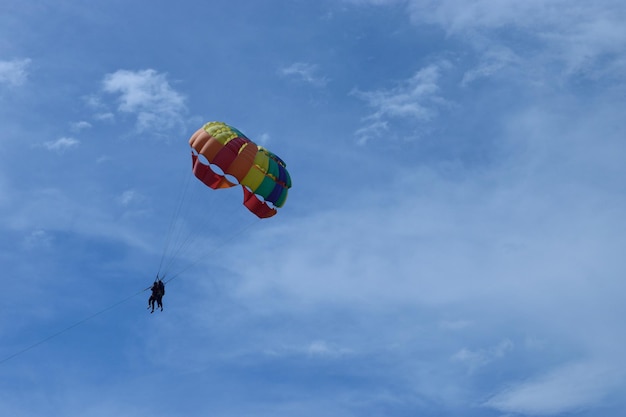 Foto niedrigwinkelansicht einer person, die gegen den himmel mit einem fallschirm fährt