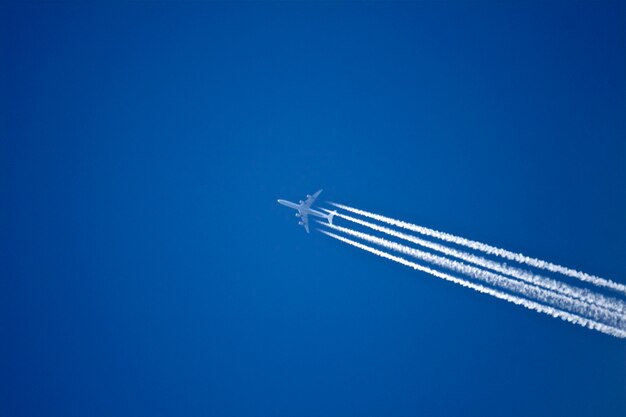 Foto niedrigwinkelansicht eines flugzeugs, das gegen einen klaren blauen himmel fliegt