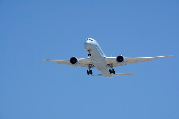 Niedrigwinkelansicht eines Flugzeugs, das gegen einen klaren blauen Himmel fliegt