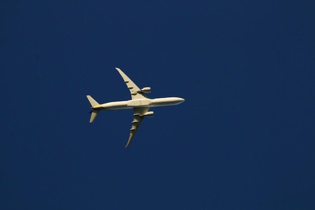 Foto niedrigwinkelansicht eines flugzeugs, das gegen einen klaren blauen himmel fliegt