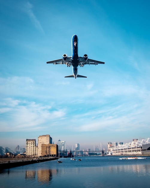Niedrigwinkelansicht eines Flugzeugs, das in der Stadt gegen den Himmel fliegt