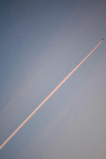 Foto niedrigwinkelansicht eines flugzeugs mit dampfspur am himmel