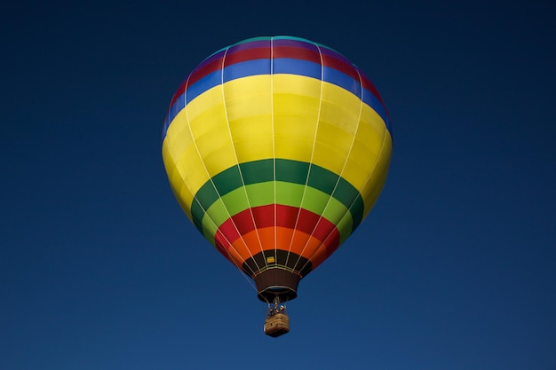 Niedrigwinkelansicht eines Heißluftballons, der gegen einen klaren blauen Himmel fliegt