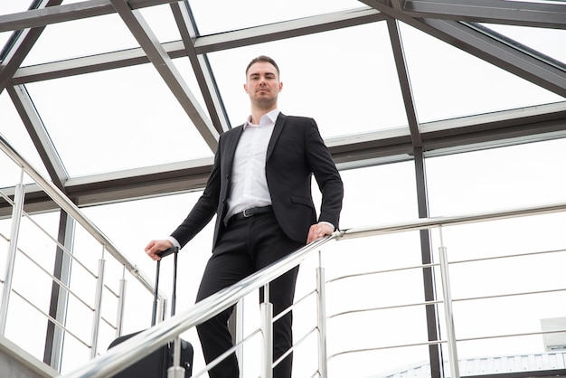 Niedrigwinkelansicht eines jungen Mannes, der gegen ein Fenster steht