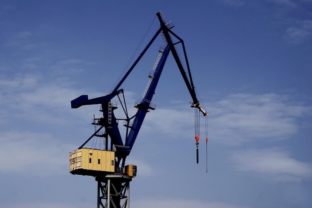 Niedrigwinkelansicht eines Kranes gegen den Himmel im Hafen