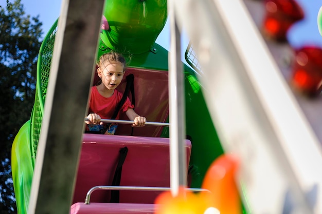 Foto niedrigwinkelansicht eines mädchens, das im vergnügungspark sitzt