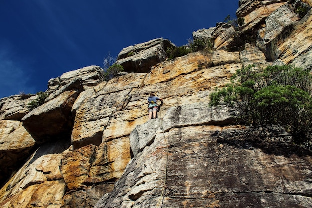 Foto niedrigwinkelansicht eines mannes, der auf einen berg klettert