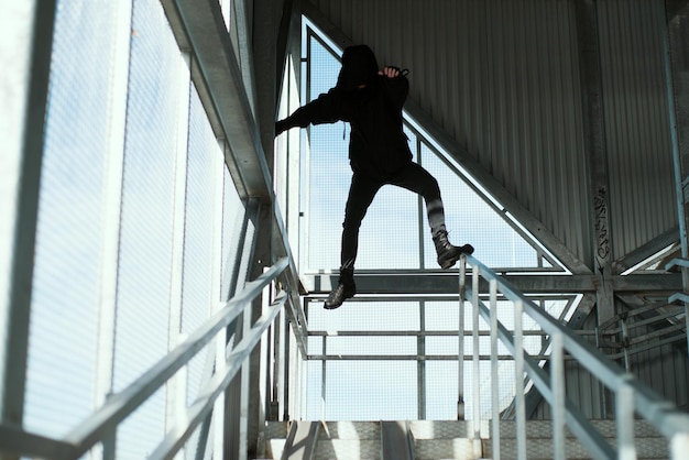 Foto niedrigwinkelansicht eines mannes, der auf einer treppe springt