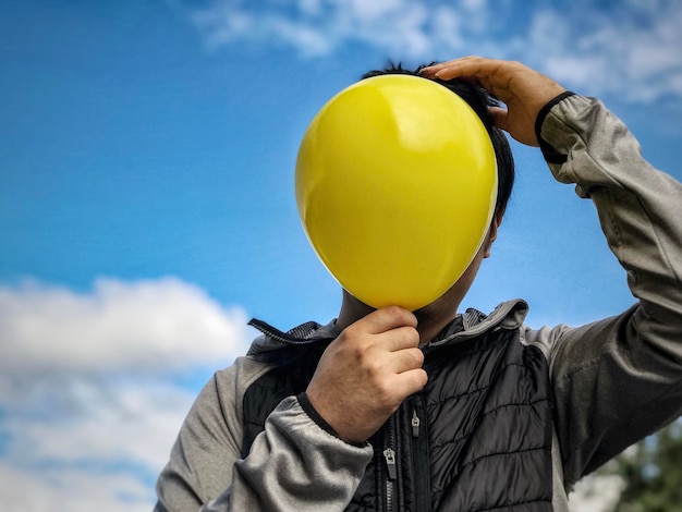 Foto niedrigwinkelansicht eines mannes mit ballons gegen den himmel