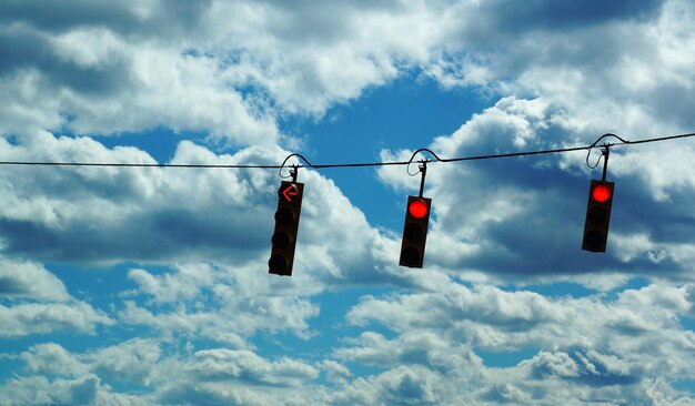 Foto niedrigwinkelansicht von ampeln gegen bewölkten himmel