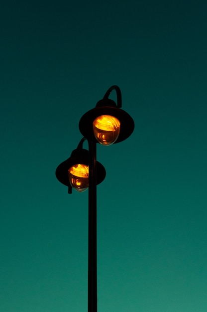 Niedrigwinkelansicht von beleuchtetem Straßenlicht gegen den blauen Himmel