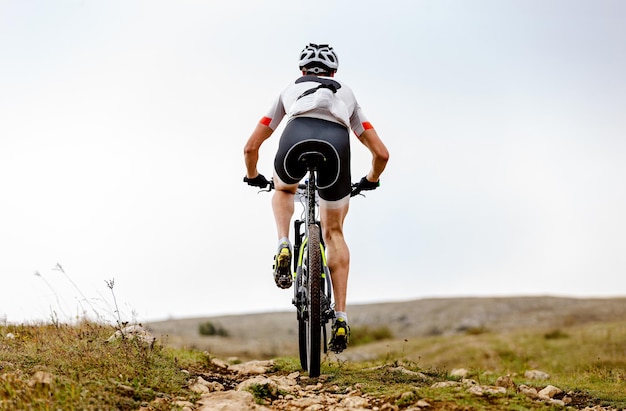 Niedrigwinkelansicht von einem Mann, der gegen den Himmel Fahrrad fährt