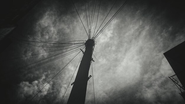 Foto niedrigwinkelansicht von einem telefonmast vor bewölktem himmel