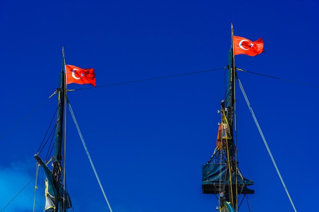 Foto niedrigwinkelansicht von flaggen, die gegen den blauen himmel hängen